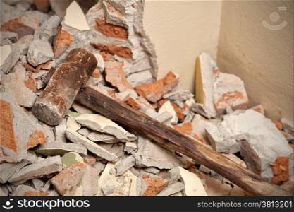 Old wood hammer on broken brick and cement in house demolition