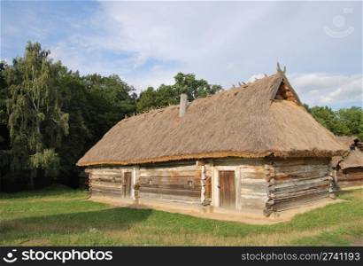 old wood log shed with thatch roof on historical country homestead