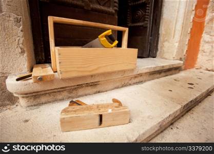 Old wood working tools on stone steps of a building
