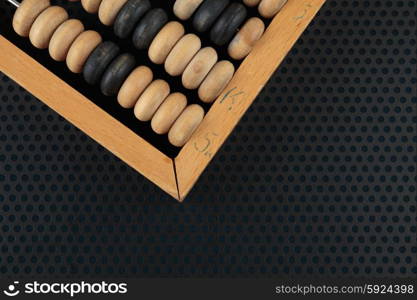 Old wooden abacus on a metallic background with perforation of round holes