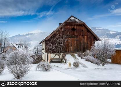 Old wooden barn covered by snow in Austrian Alps