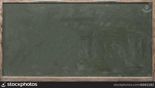 old wooden blackboard with chalk stains and rubbed writing