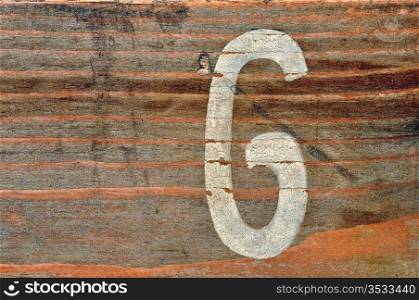 Old wooden board with number six faded stencil. Wood grunge background.