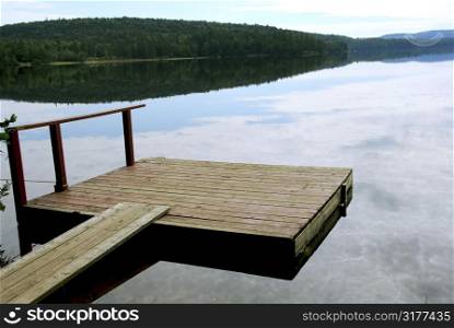 Old wooden boat dock on a beautiful lake in the evening