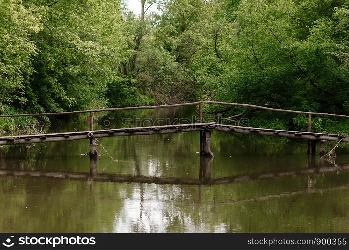 Old wooden bridge, wooden bridge across a small river, bridge with nature. Old wooden bridge, wooden bridge across a small river, bridge with nature.