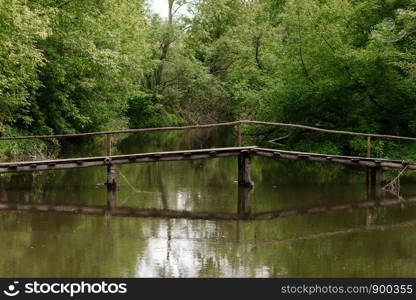 Old wooden bridge, wooden bridge across a small river, bridge with nature. Old wooden bridge, wooden bridge across a small river, bridge with nature.