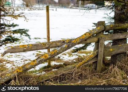 Old wooden broken fence at farm in winter