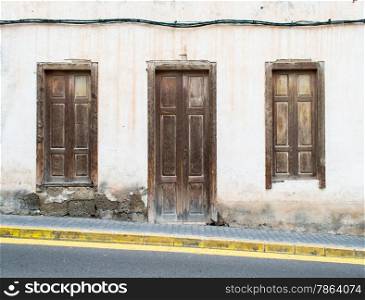 Old Wooden Door and Shutters on Inclined Road