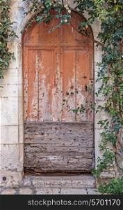 Old wooden door in the entrance stone French house