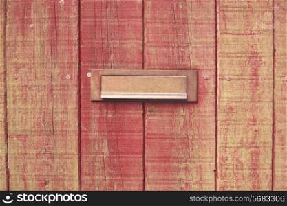 Old wooden door with a brass letterbox