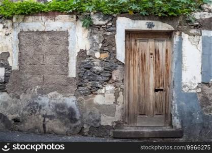 Old wooden doors in a dilapidated stone building.. Old wooden doors in dilapidated stone building.