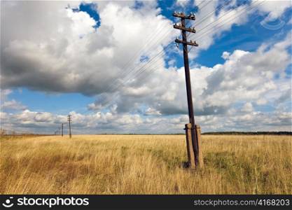 Old wooden electric pillar in the field