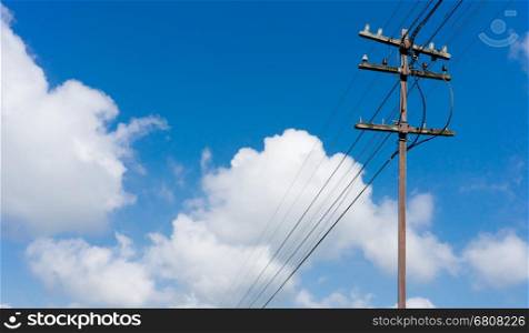 Old wooden electric pole and blue sky background