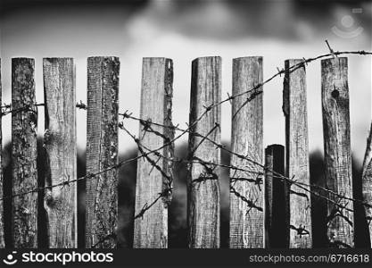 old wooden fence with rusted barbed wire