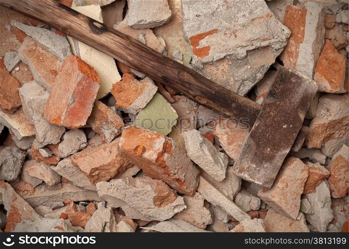 Old wooden hammer on broken brick wall background