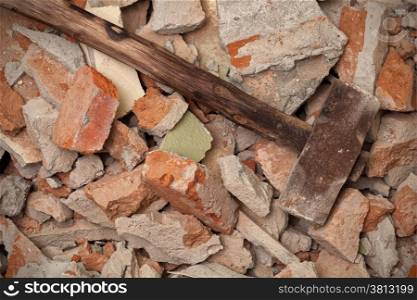 Old wooden hammer on broken brick wall background