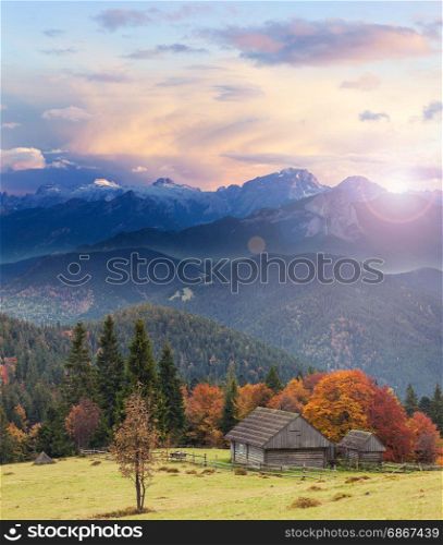 Old wooden house on the high mountain hill at sunrise