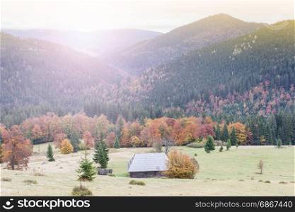 Old wooden house on the mountain hill at sunrise