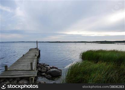 Old wooden jetty by the coast of Baltic Sea at the swedish island Oland