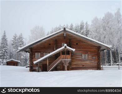 "Old wooden peasant house in Northern Russia near Arkhangelsk. Tourist complex "Malye Korely", winter time."