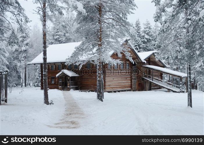 "Old wooden peasant house in Northern Russia. Tourist complex "Malye Korely", winter time."