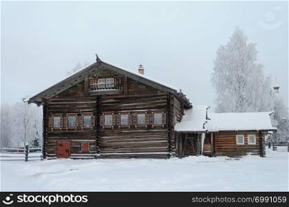 Old wooden peasant house in the northern open air museum Malye Korely near Arkhanglesk, Primorsk Region, Russia. Winter frosty day.