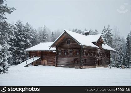 "Old wooden peasant house with yard in Northern Russia. Tourist complex "Malye Korely", winter time."