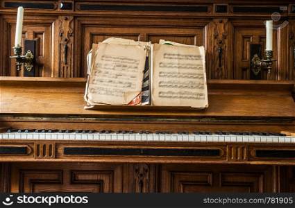 Old wooden piano keys on wooden musical instrument in front view, antique fashioned, close-up. Old wooden piano keys on wooden musical instrument in front view, antique fashioned