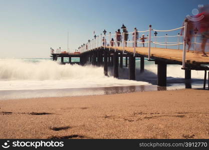 Old wooden pier over the sea shore, tinted photo