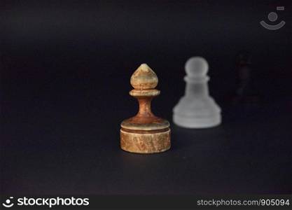 Old wooden ponce on the dark background and white glass ponce aside out of focus