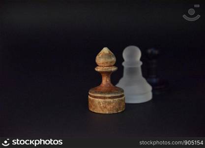Old wooden ponce on the dark background and white glass ponce aside out of focus