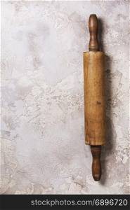 Old wooden rolling pin on rustic stone background. Top view with copy space