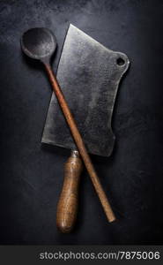 old wooden spoon and Meat cleaver knife on dark background