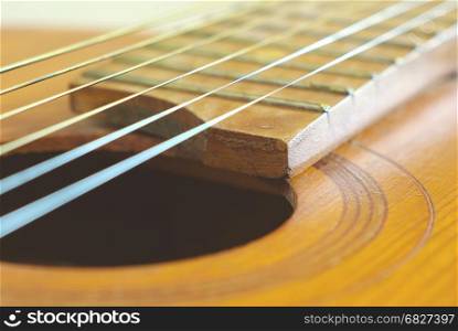 Old wooden string guitar closeup. Vintage acoustic music background. Musical classical instrument.