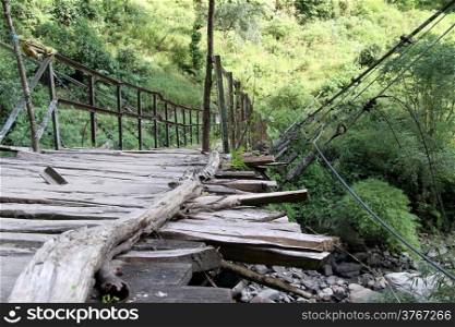Old wooden suspension bridge in mountain in Nepal