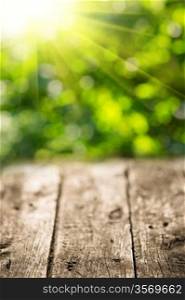 Old wooden table against spring green background