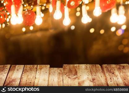 Old wooden table with light bulb illuminaion at night city street