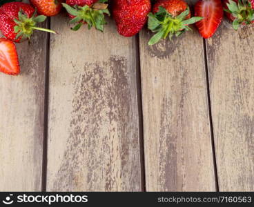 Old wooden texture with ripe strawberries. Fresh strawberries on old wooden background