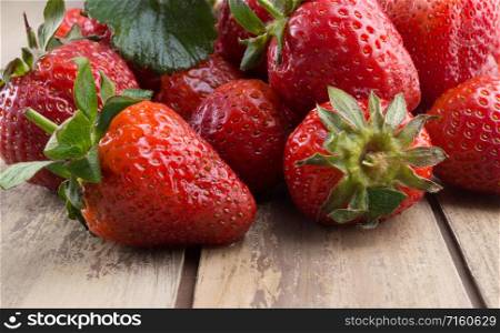Old wooden texture with ripe strawberries. Fresh strawberries on old wooden background