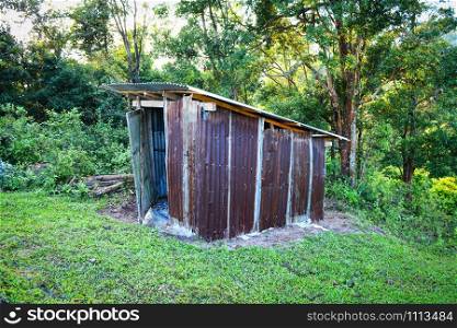 Old wooden toilet forest with zinc roof on mountains in a village hill - Outhouse toilet cabins