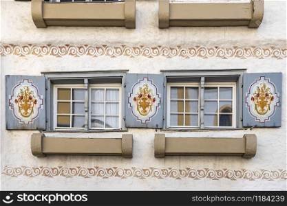 Old wooden window with blinds and curtains. Scenic original and colorful view of antique windows in the old city in Germany. No people. Front view. Old fashioned style.