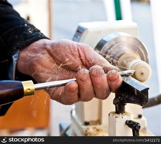 Old worker hands at lathe