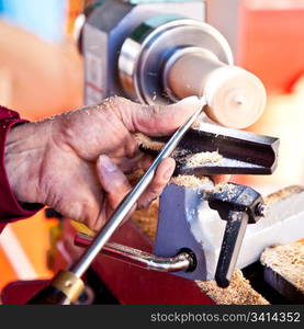 Old worker hands at lathe