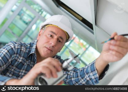 old worker in white helmet repairing