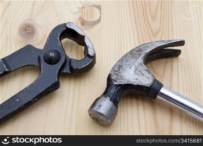 Old wrench and hammer closeup on wood background