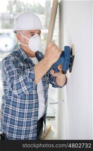 olde man repainting a wall indoors