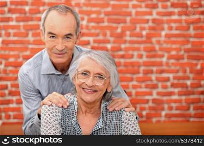Older couple in front of a brick wall