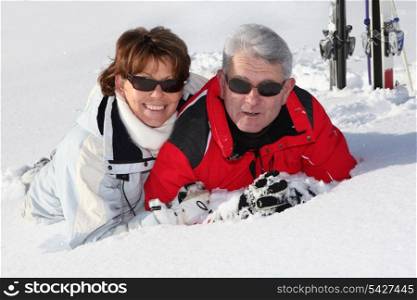 Older couple lying in the snow