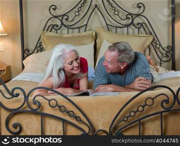 Older couple reading on bed