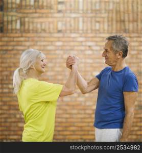 older couple shaking hands gym